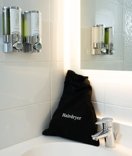 sèche-cheveux dans la douche d’une chambre de l’OSKO Hôtel Toulouse-Blagnac