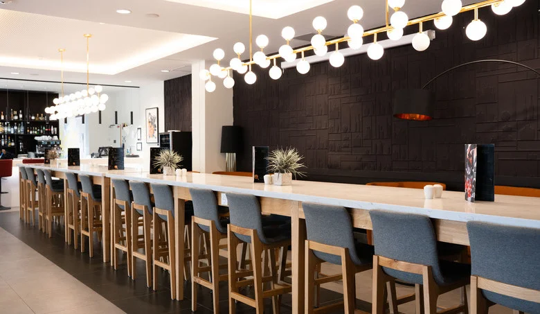 bar de l’OSKO Hôtel Toulouse-Blagnac avec grande table et ambiance conviviale